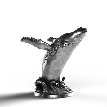 Silver statue of a breaching humpback whale, 999 fine silver craftsmanship.